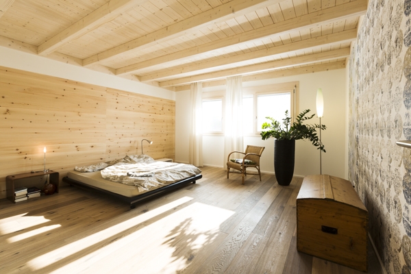 Schlafzimmer aus Holz mit Bett und viel Licht